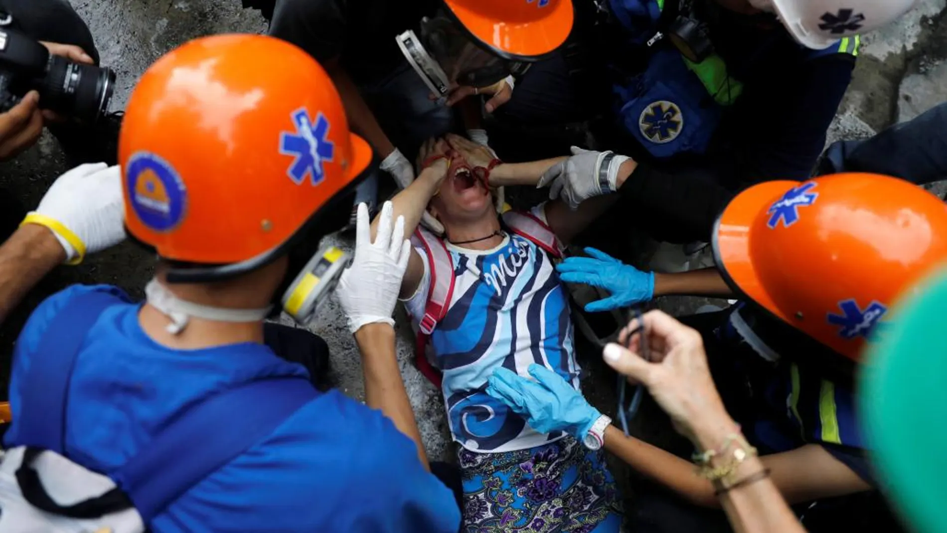 Un manifestante es asistido por durante una manifestación contra el gobierno del presidente de Venezuela, Nicolás Maduro, en Caracas