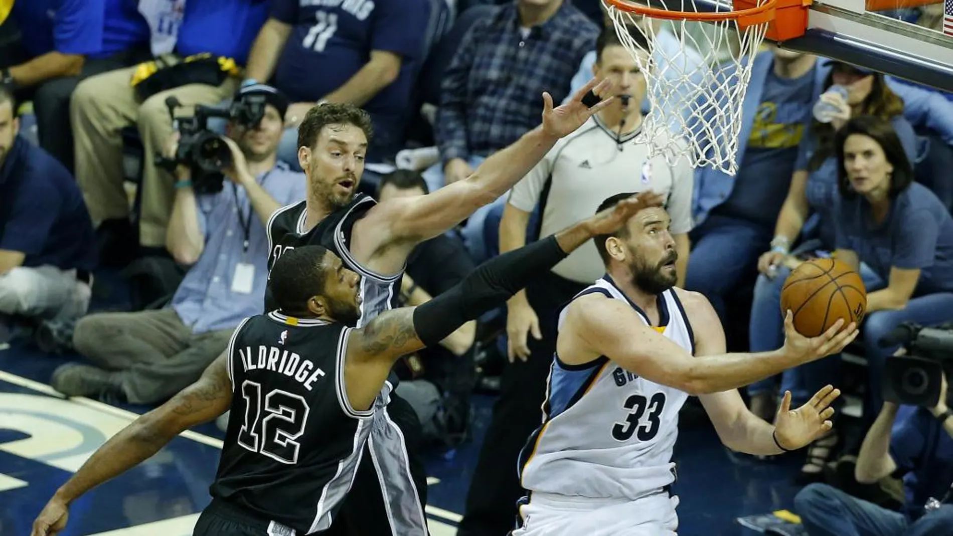 El central de los Memphis Grizzlies, el español Marc Gasol (d), lanza el balón ante los delantero de los Spurs LaMarcus Aldridge, y su hermano, Pau Gasol.