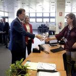 El presidente del Gobierno en funciones, Mariano Rajoy, acompañado por la ministra de Empleo, Fátima Báñez, entre otros, saluda a una trabajadora de la Seguridad Social.