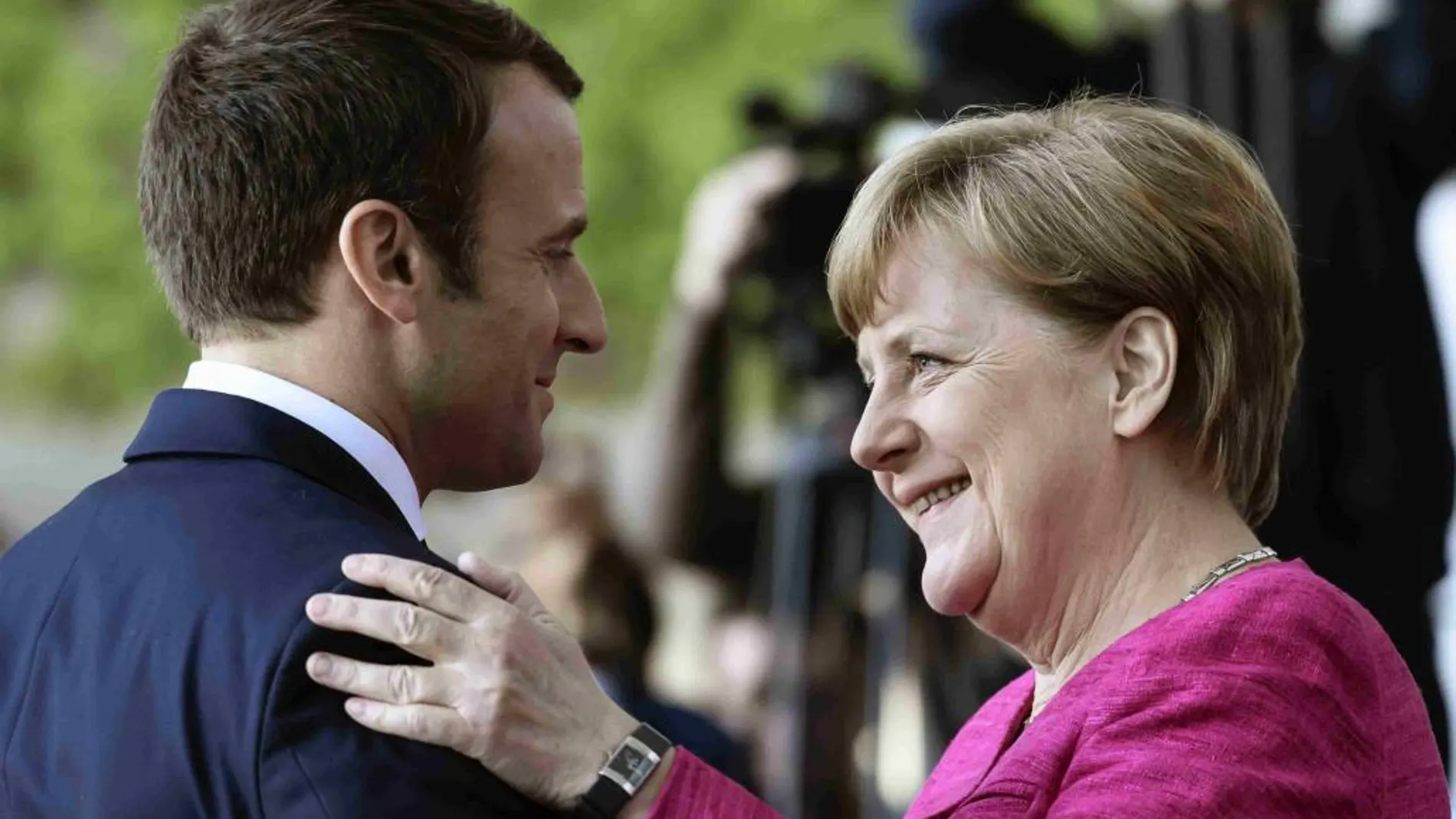 La canciller alemana Angela Merkel (i) y el presidente francés Emmanuel Macron (d) antes de la rueda de prensa tras su encuentro en la cancillería alemana en Berlín.