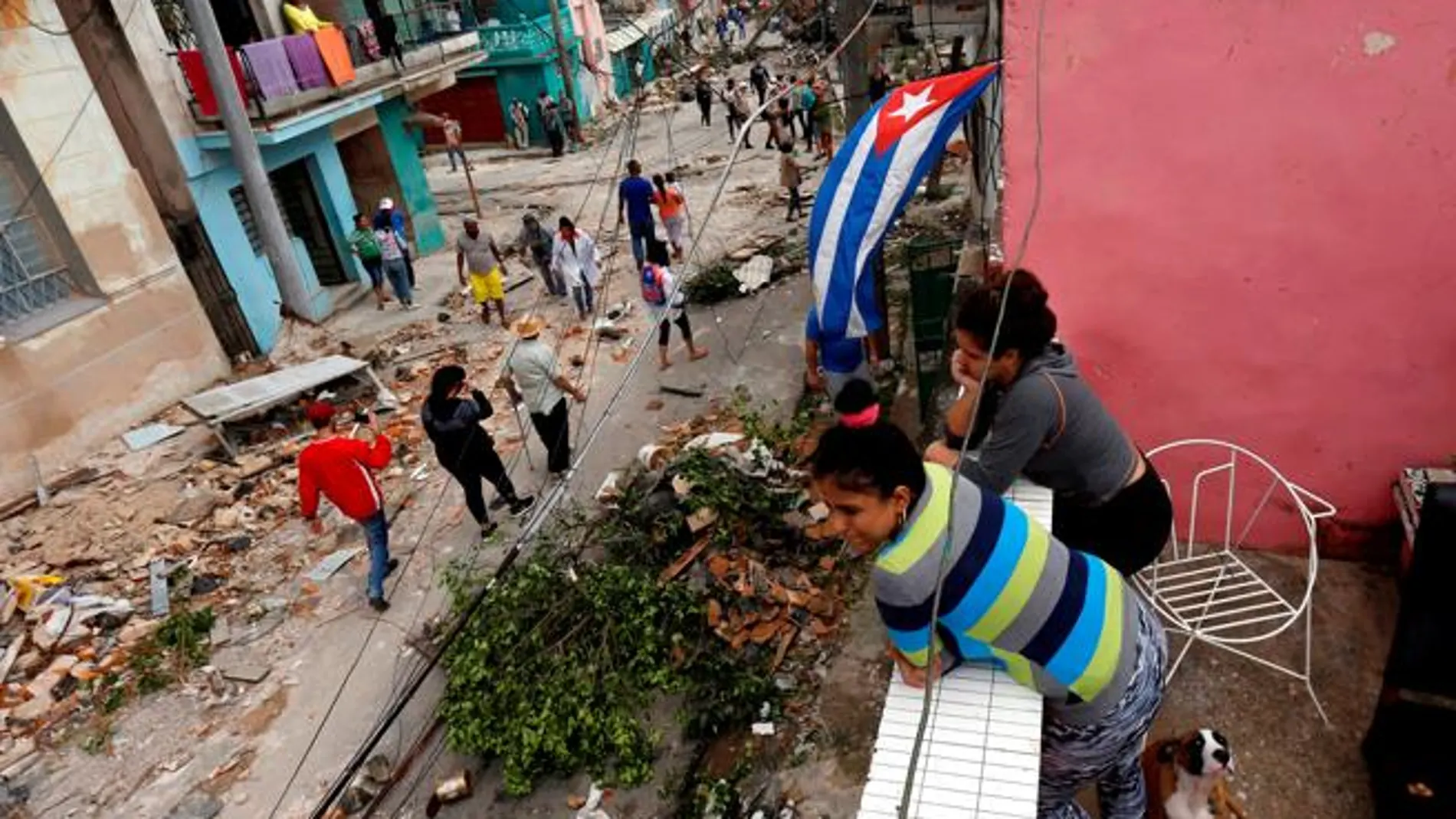 La gente observa mientras otros pasan junto a los escombros después de que el tornado arrasara un barrio en La Habana / Reuters