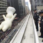 Agentes del Departamento de Policía de Nueva York, vigilan desde una azotea por la seguridad del desfile a su npaso por la Sexta Avenida