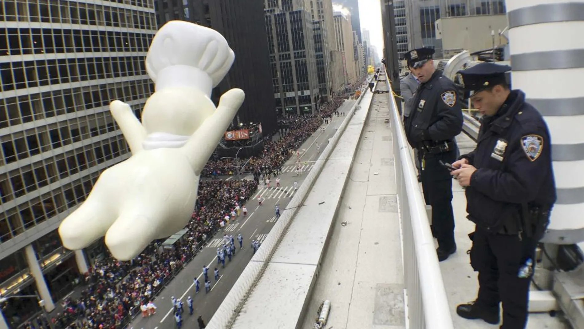 Agentes del Departamento de Policía de Nueva York, vigilan desde una azotea por la seguridad del desfile a su npaso por la Sexta Avenida