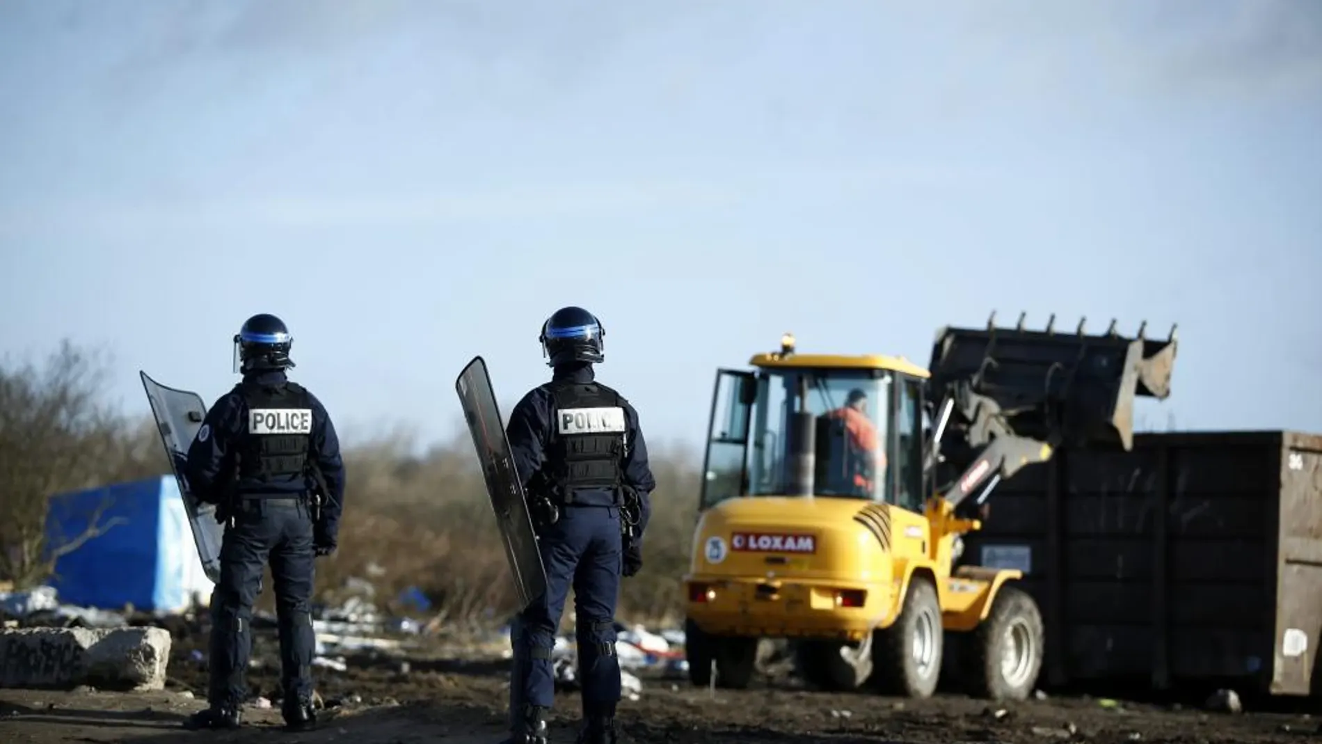 Policías franceses permanecen en guardia en el campamento conocido como"La Jungla"durante los trabajos de demolición.
