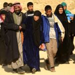 Un grupo de desplazados camina dirección a Mosul, en un territorio en el que se desarrolla una batalla entre las fuerzas iraquíes y los seguidores del Estado Islámico