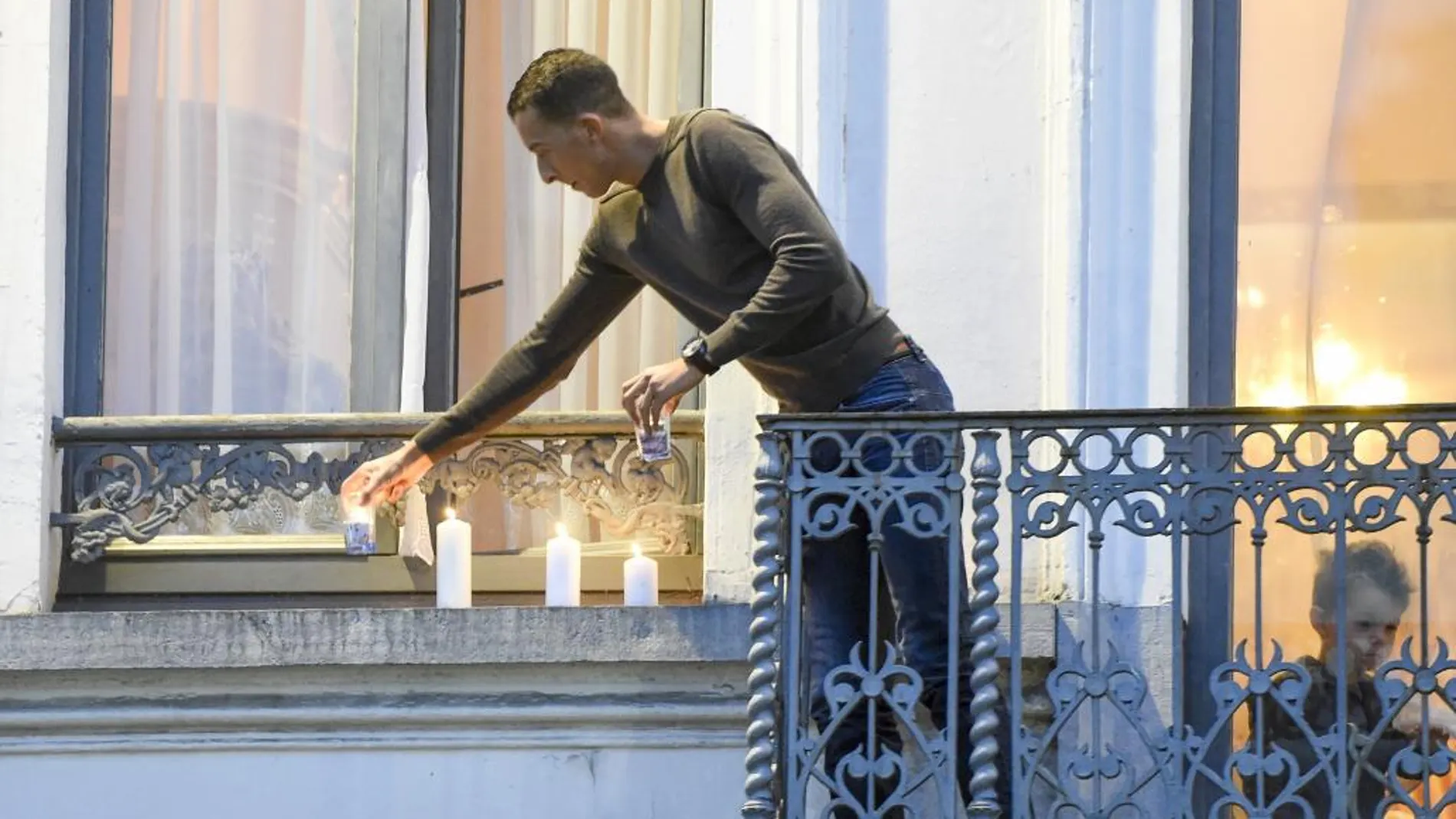 Mohamed Abdeslam, hermano de Ibrahim Abdeslam, coloca unas velas en el balcón de su casa en Bruselas como para mostrar su repulsa por los atentados