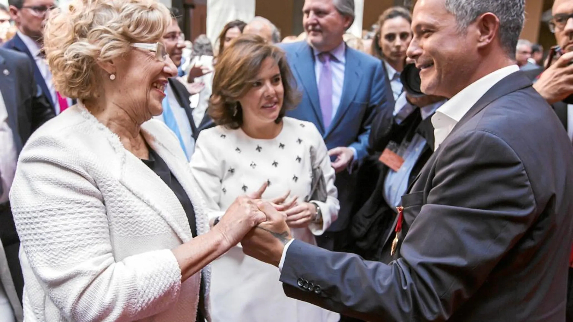 La alcaldesa, Manuela Carmena, y la vicepresidenta, Sáenz de Santamaría, saludaron en el acto a Alejandro Sanz