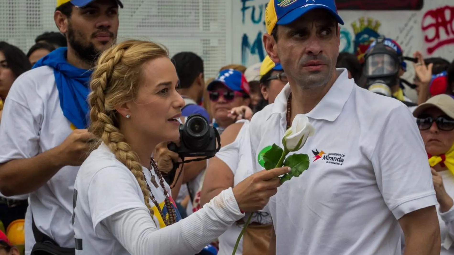 La esposa del líder opositor preso Leopoldo López, Lilian Tintori, habla con el líder opositor y gobernador del estado Miranda Henrique Capriles, durante una manifestación ayer