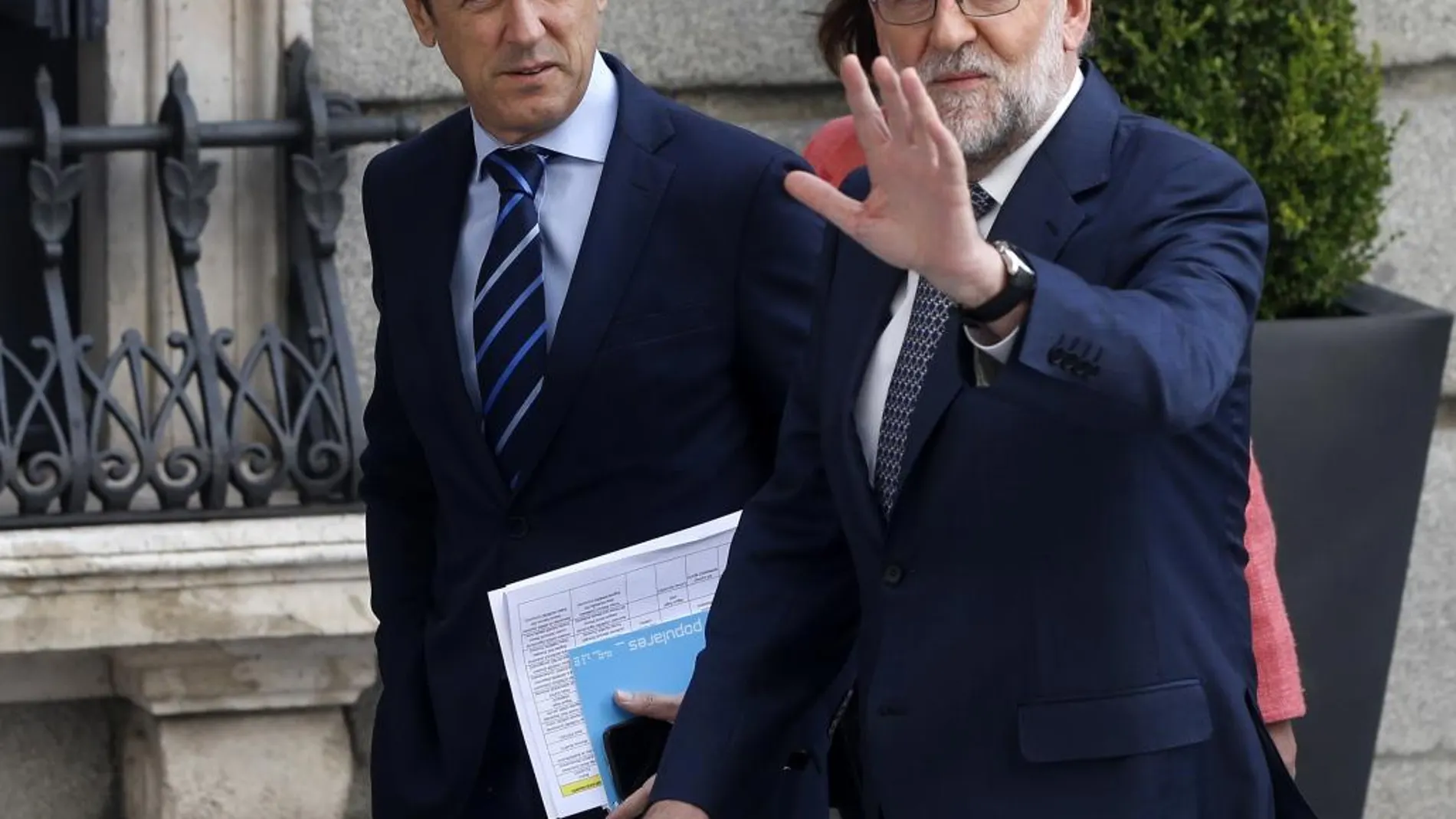 El jefe del Gobierno en funciones, Mariano Rajoy, saluda junto al portavoz, Rafael Hernando, en el Congreso.