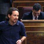 El líder de Podemos, Pablo Iglesias, pasa delante del escaño del secretario general del PSOE, Pedro Sánchez