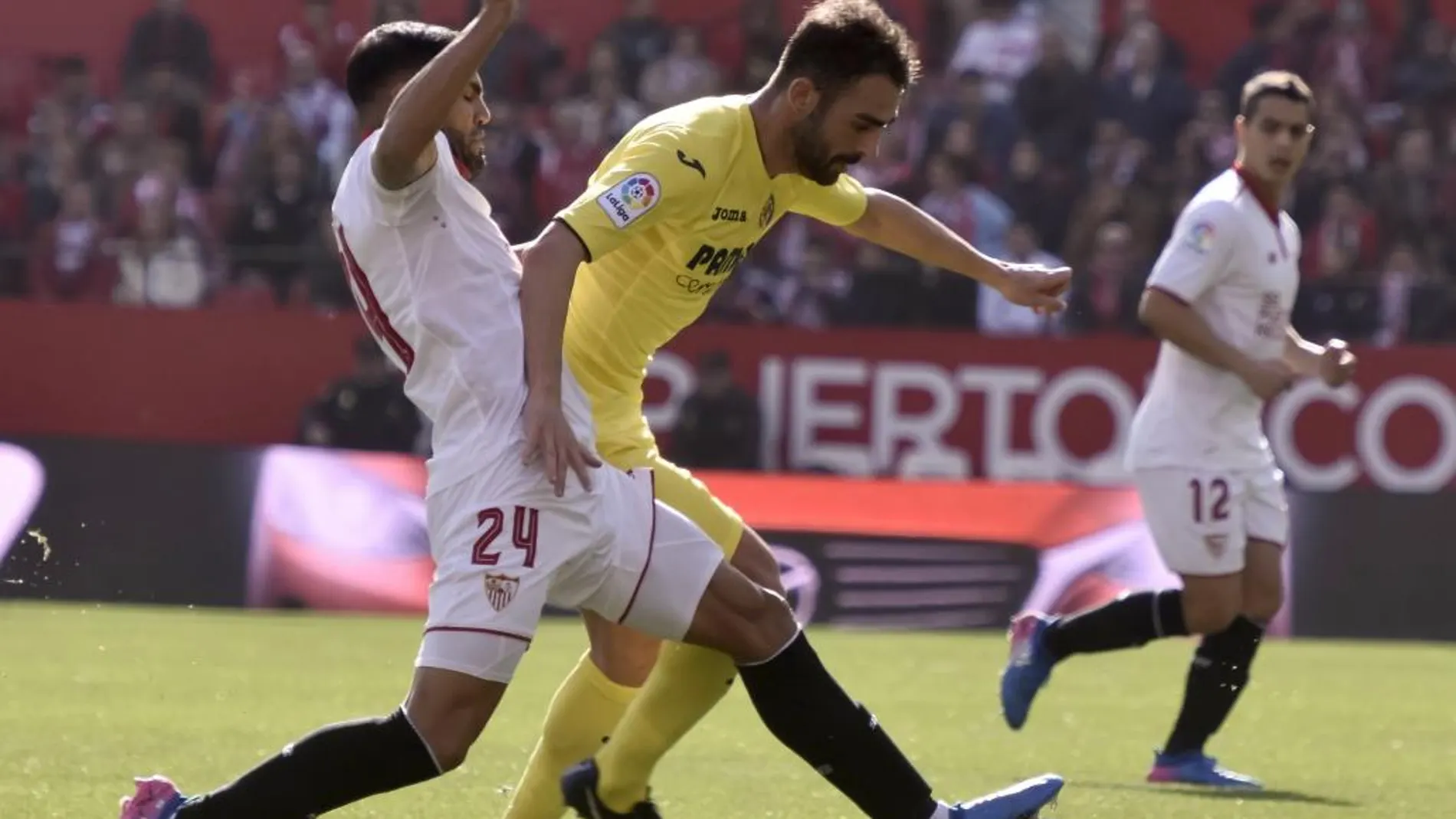 El defensa argentino del Sevilla FC Gabriel Mercado (i) disputa un balón con el delantero del Villarreal CF Adrián López (d)
