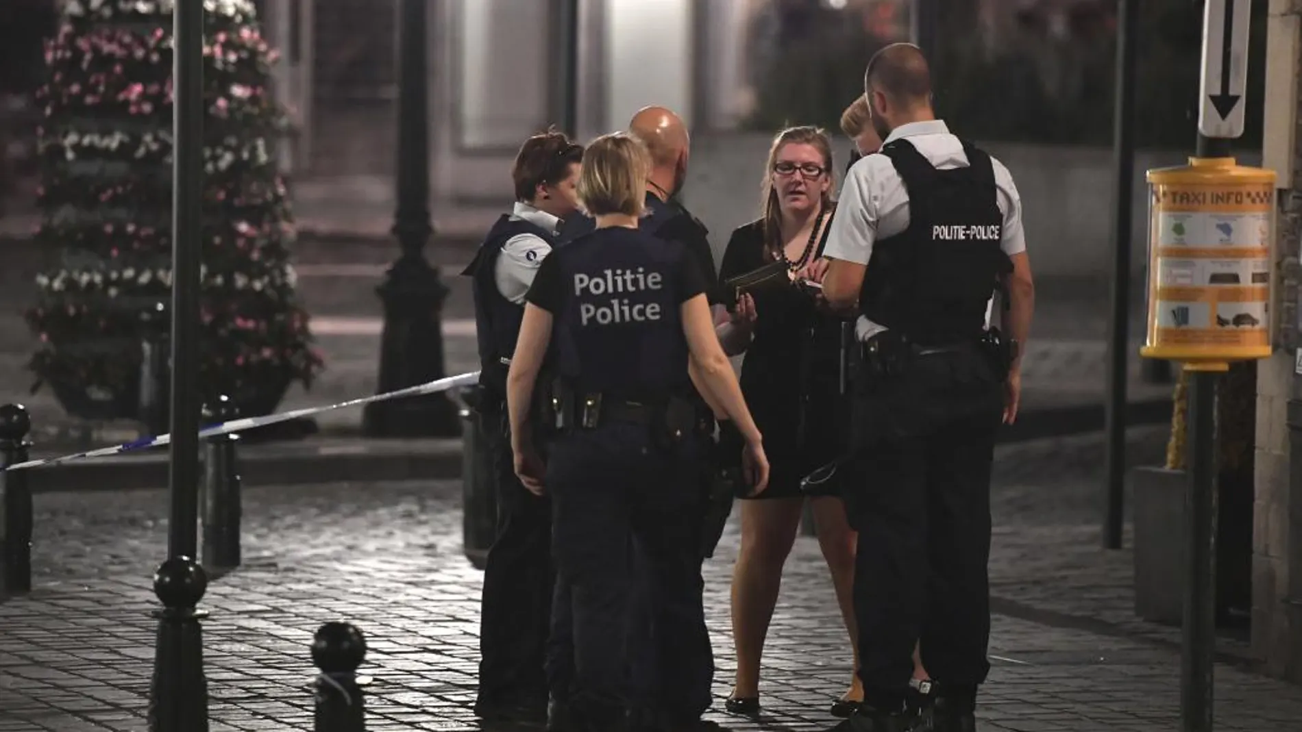 La Policia belga habla con una mujer cerca de la Estación Central de Bruselas después de producirse la explosión.