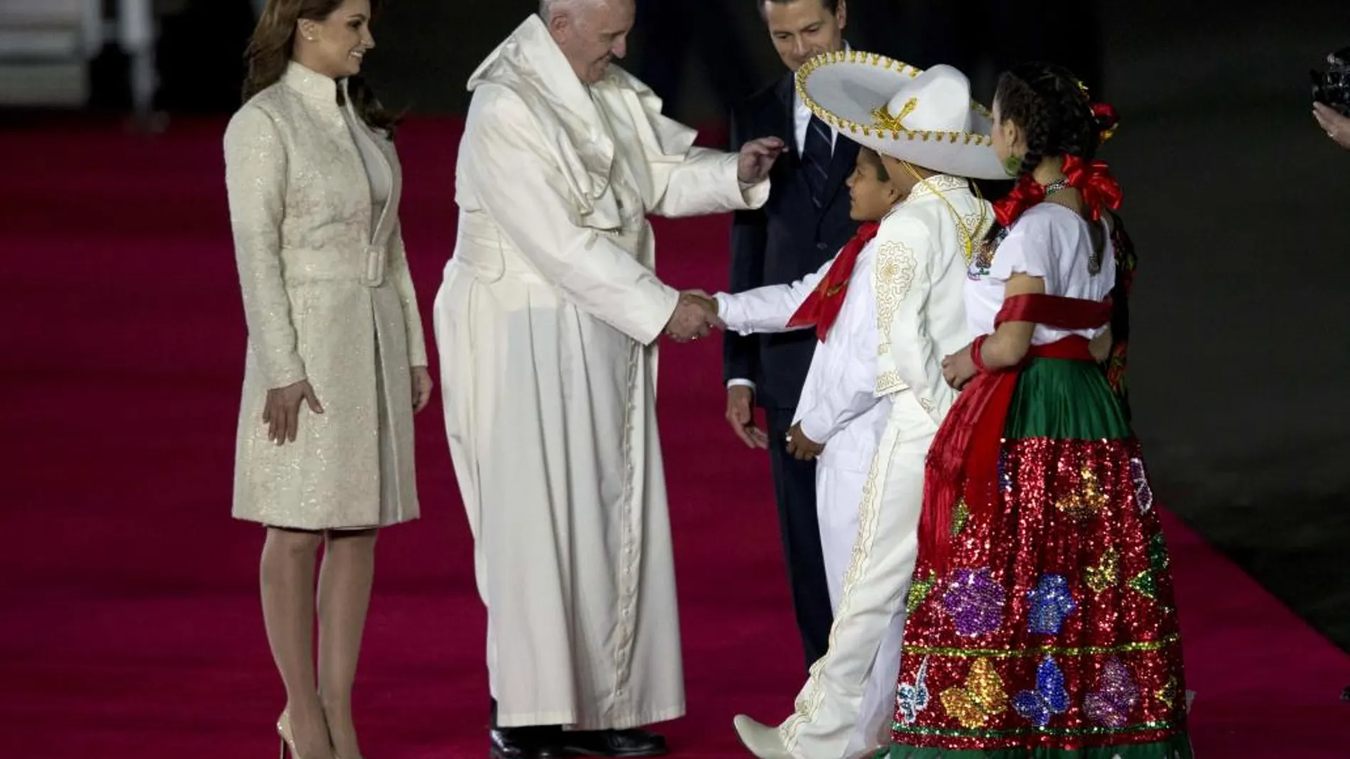 El Papa saluda a una familia de mexicanos vestidos con trajes tradicionales, junto al presidente de México y su esposa
