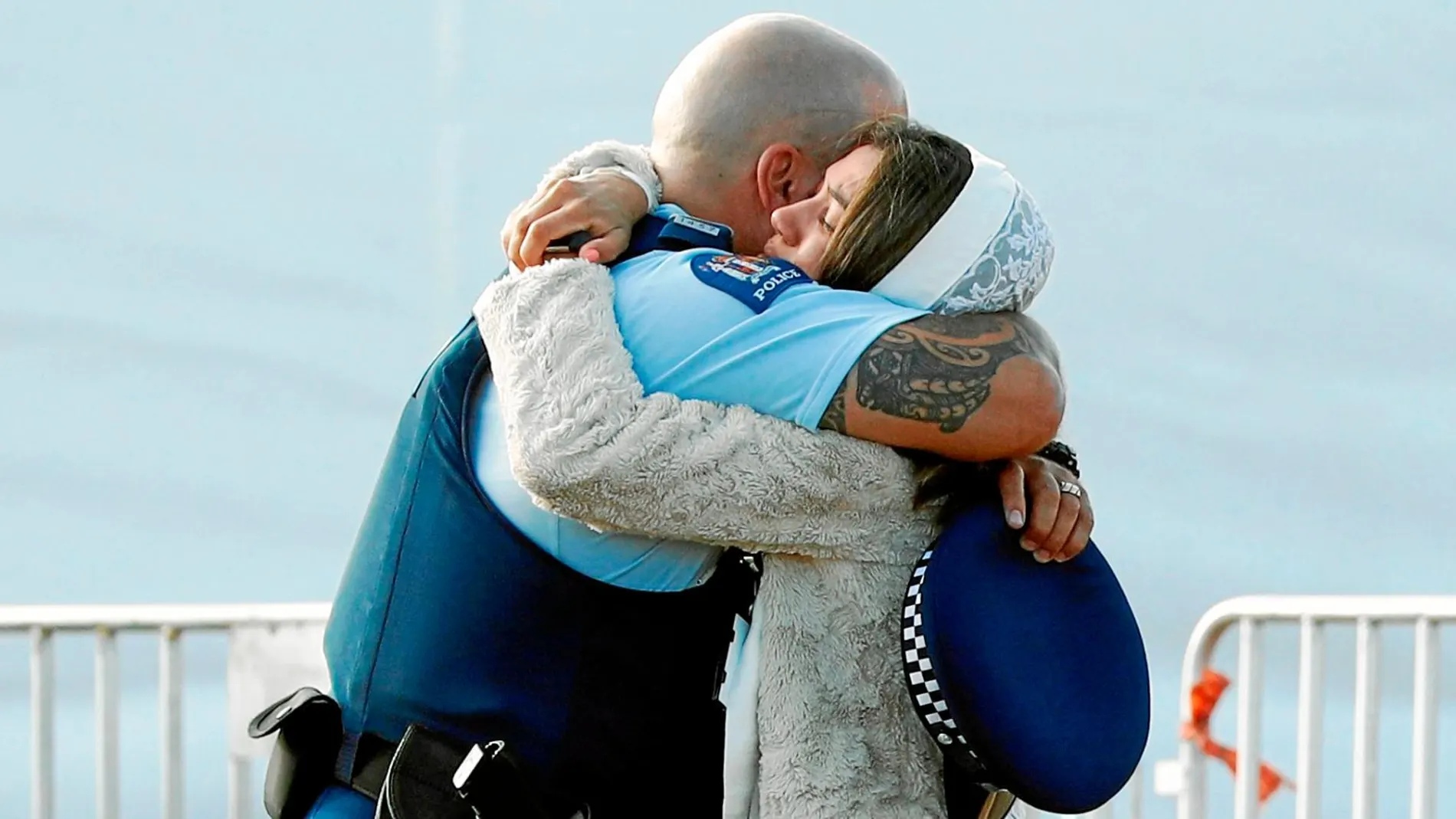 Un familiar de una víctima abraza a un policía durante los entierros múltiples por las víctimas en Christchurch, ayer / Reuters