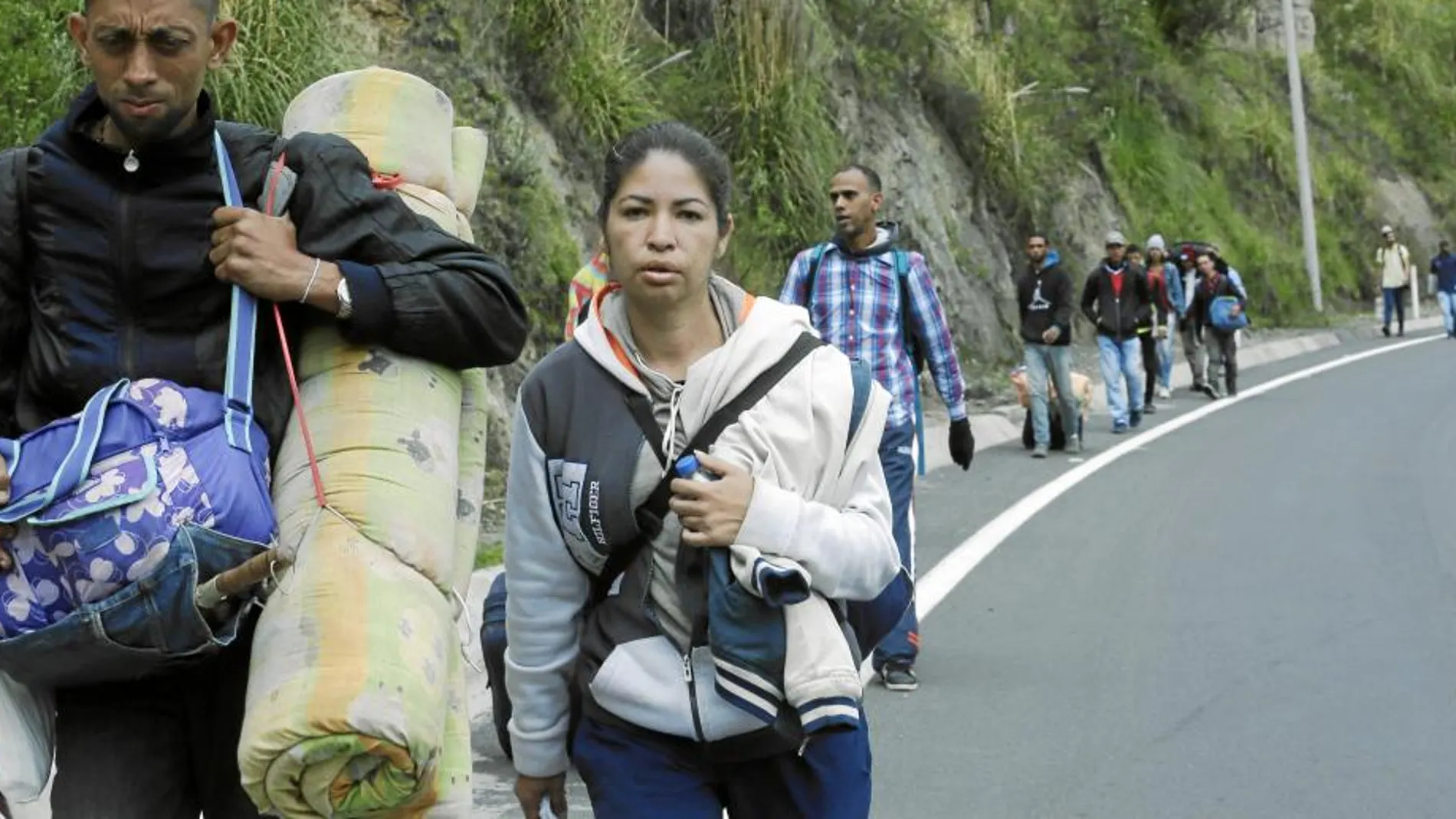 Venezolanos sin pasaporte siguen ayer la autopista panamericana tras cruzar el puente de Rumichaca, en la frontera entre Colombia y Ecuador