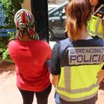 Una agente custodia a una de las mujeres liberadas durante la operación