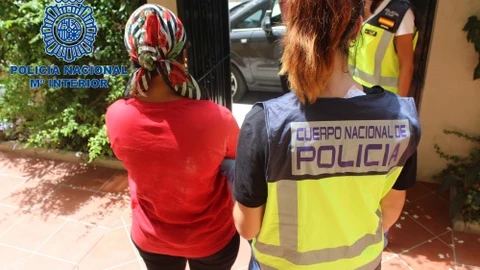 Una agente custodia a una de las mujeres liberadas durante la operación