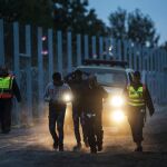 Policías húngaros escoltan a migrantes tras entrar en Hungría desde Serbia