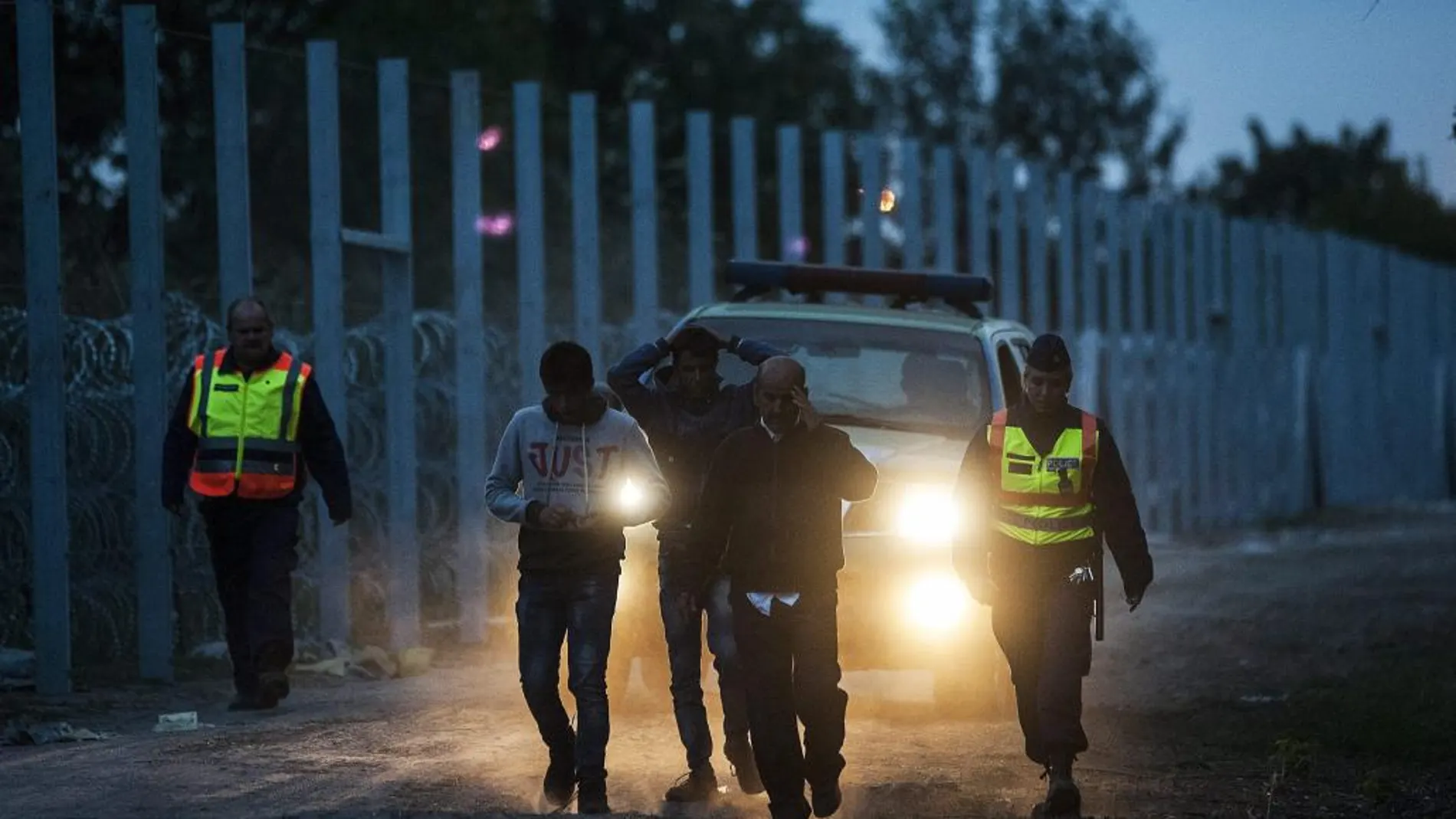 Policías húngaros escoltan a migrantes tras entrar en Hungría desde Serbia
