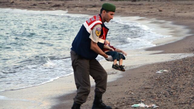 Un agente lleva en brazos el cuerpo del pequeño Aylan