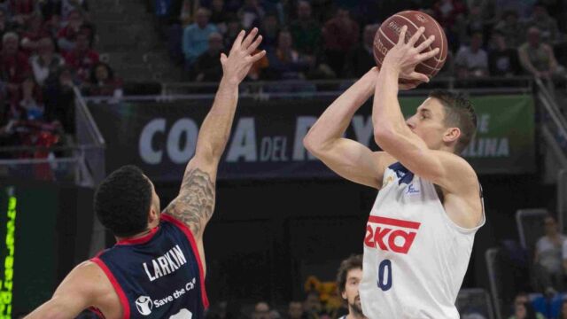 El escolta estadounidense del Real Madrid, Jaycee Carroll lanza a canasta ante su compatriota, el base del Baskonia, Shane Larkin.