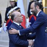 El primer ministro francés, Èdouard Philippe (dcha.) saluda afectuosamente a su antecesor, Bernard Cazeneuve