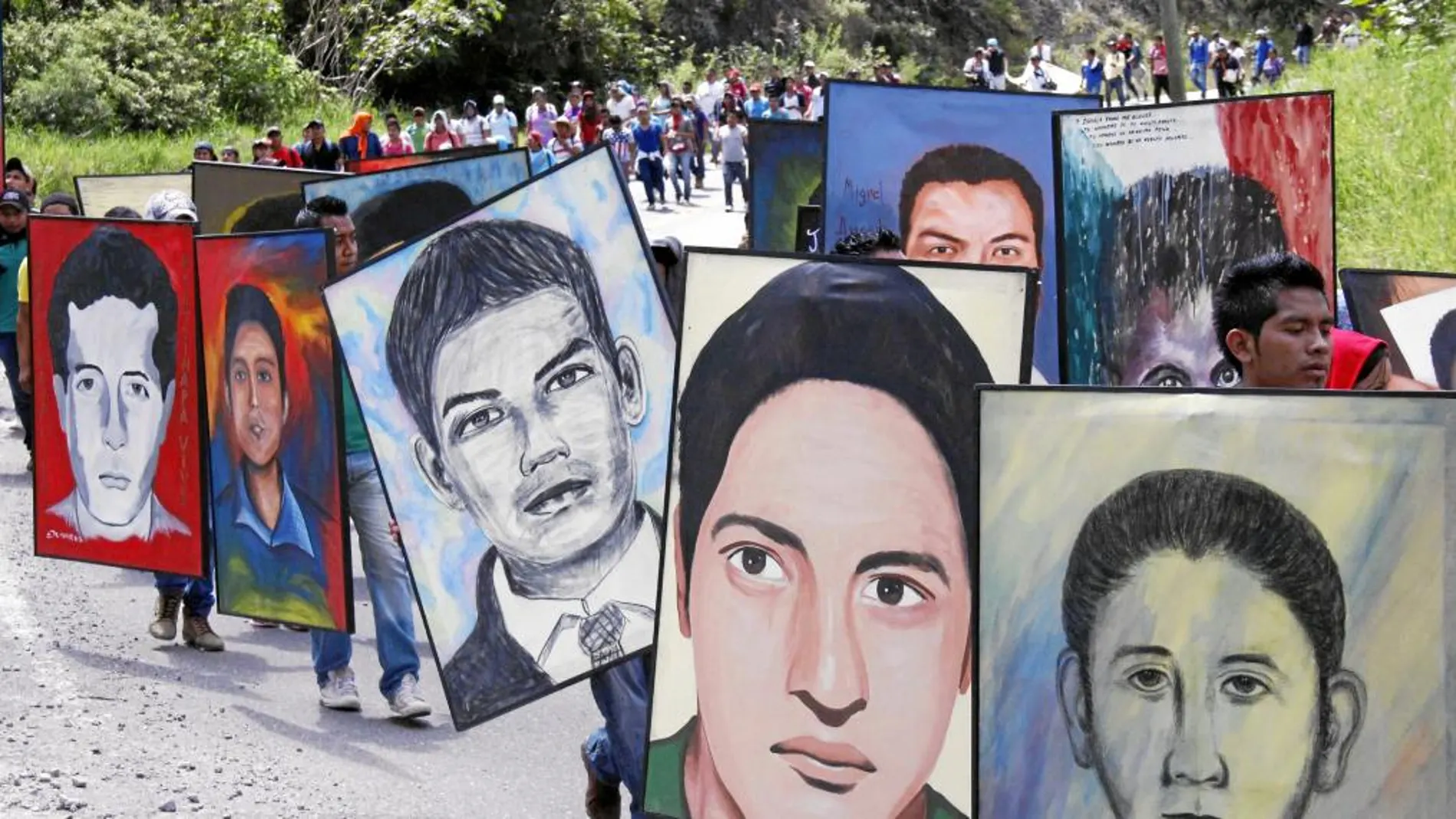 Normalistas de la escuela rural de Ayotzinapa sostienen retratos de los 43 estudiantes desaparecidos durante una manifestación en Chilpancingo