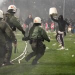 Agentes antidisturbios griegos tratan de controlar a los aficionados que invadieron el campo de fútbol
