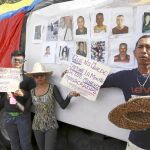 Vecinos con fotos de las víctimas, ayer, piden justicia por las desapariciones