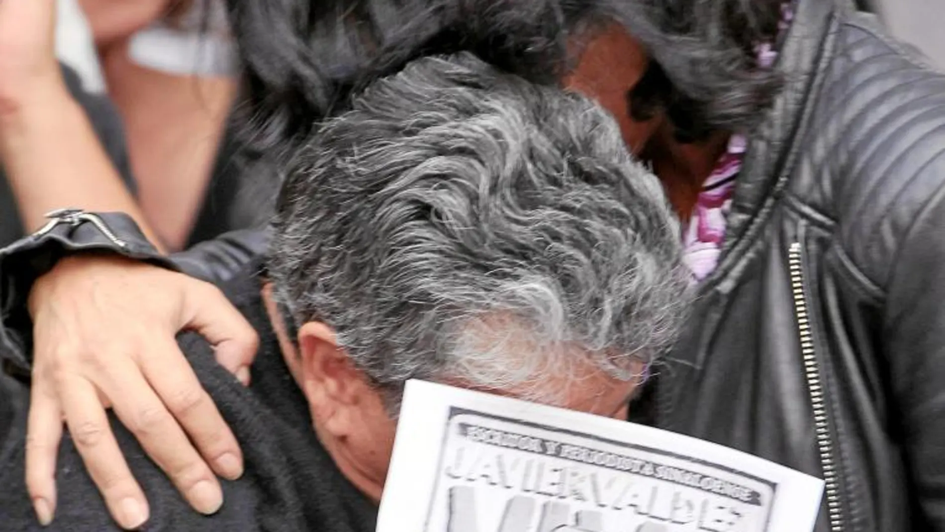 Dos mujeres lloran con una imagen de Valdez en una protesta