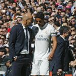 El central francés del Real Madrid Raphael Varane habla con el técnico madridista, Zinedine Zidane, tras retirarse lesionado