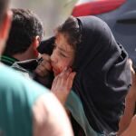 Un hombre traslada a un niña herida durante el bombardeo cerca de Alepo