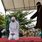 Una mujer es flagelada por violar la ley islámica o &quot;sharía&quot;en la Gran Mezquita de Baiturrahman en Banda Aceh, en la región indonesia de Aceh