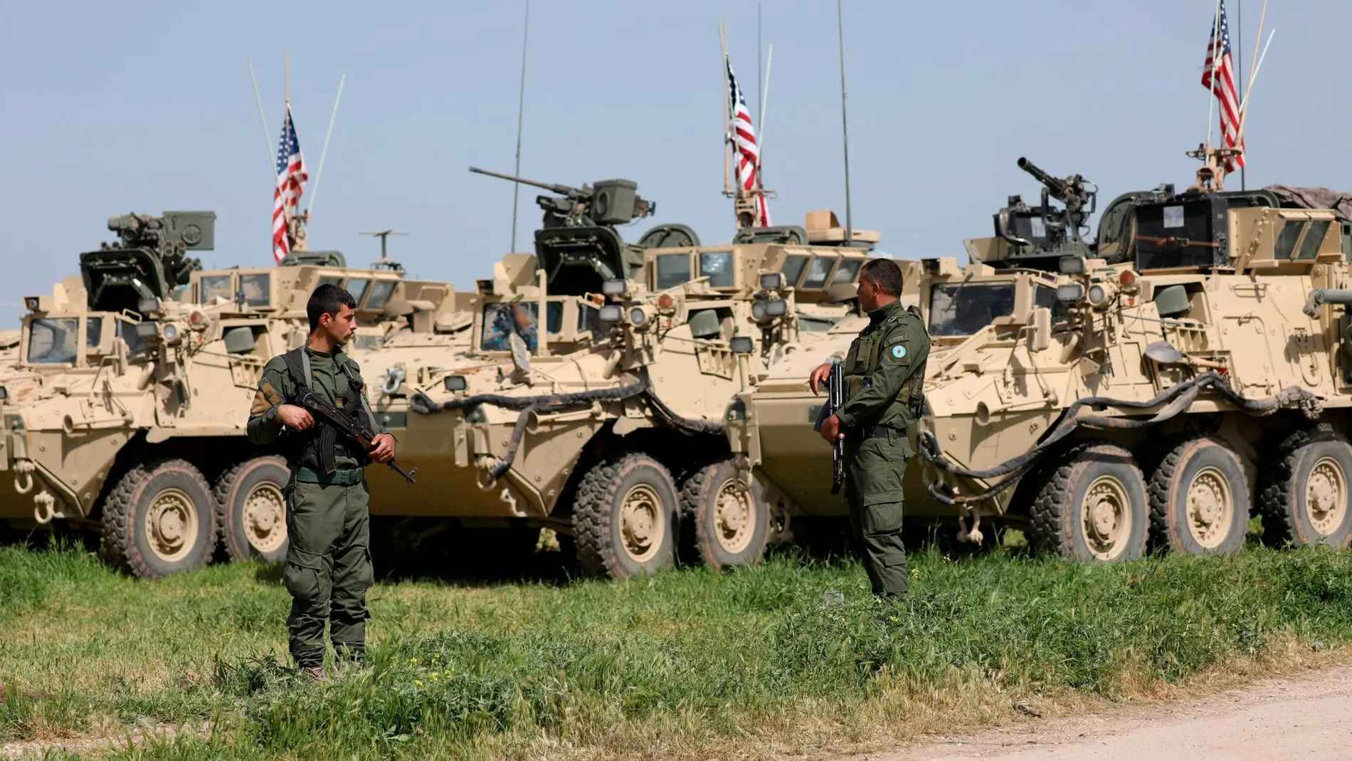 Milicianos kurdos, junto a vehículos militares de EE UU, en la localidad siria de Darbasiya cerca de la frontera con Turquía / Foto: Reuters