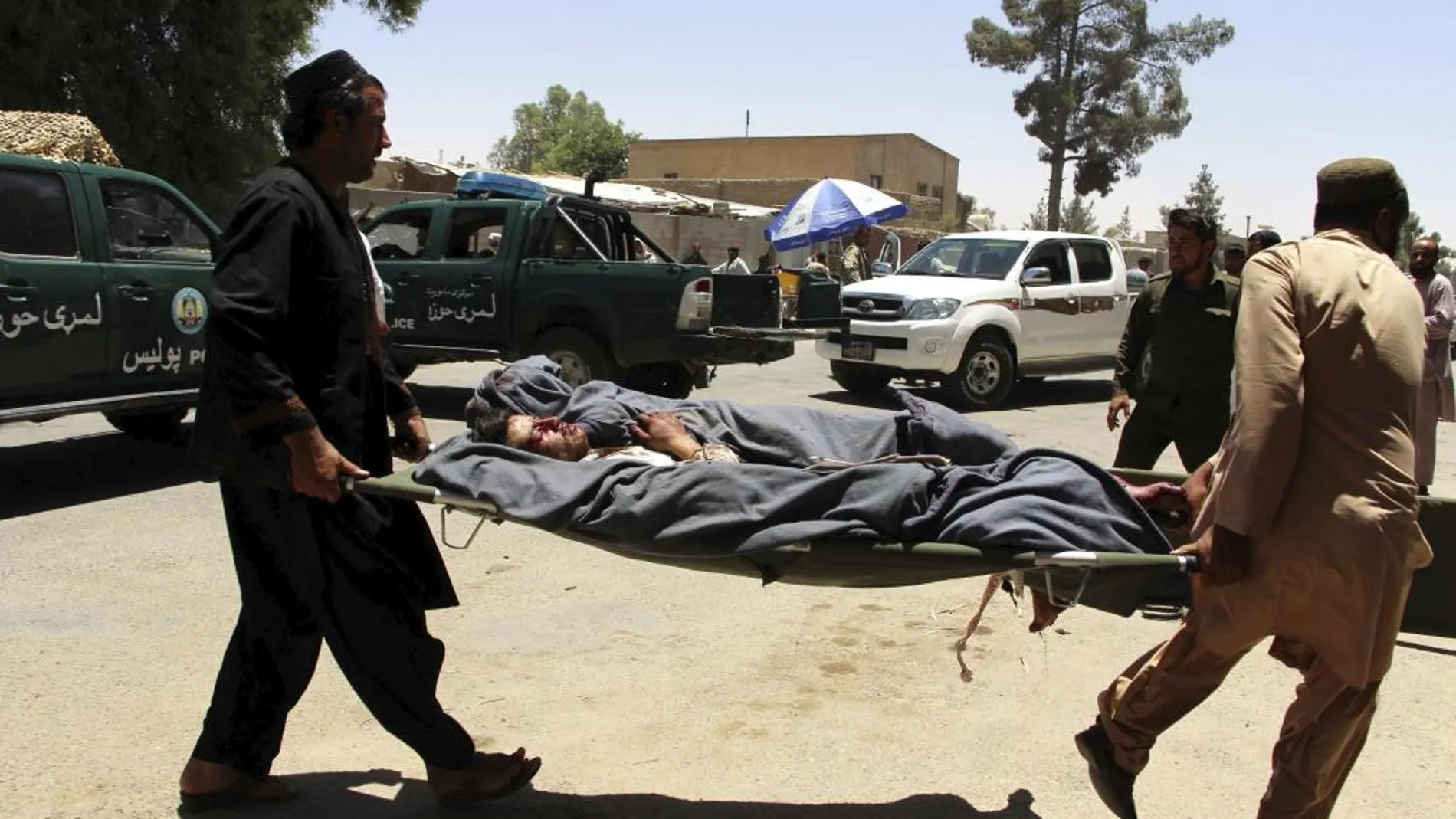 Un hombre afgano es trasladado en camilla tras resultar herido en el atentado suicida frente a una sucursal bancaria