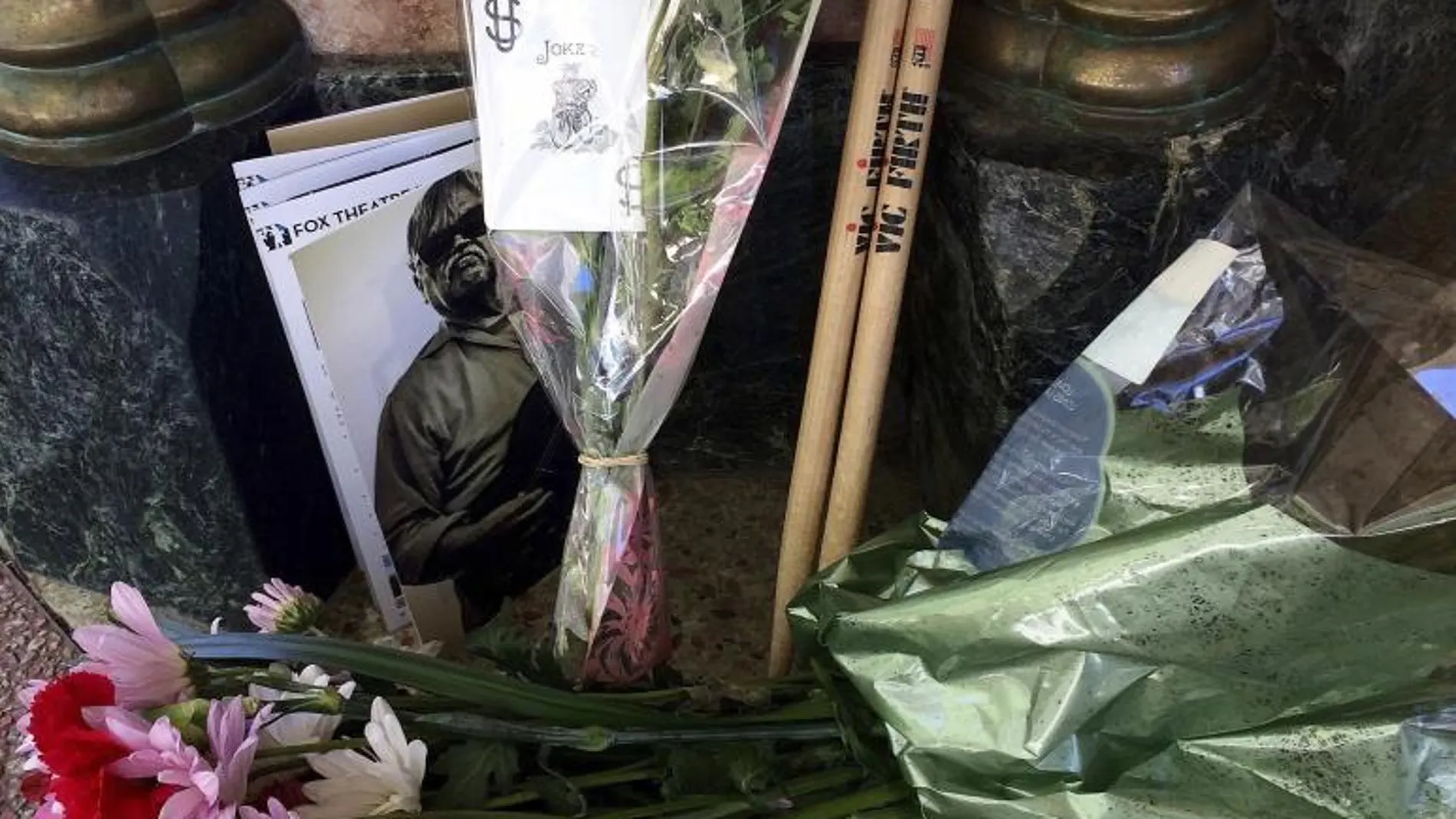 Velas y flores en homenaje a Bruce Hampton.