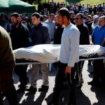 Varias personas acompañan el cadáver del rabino israelí Achad Ettinger, herido mortalmente en un ataque palestino.