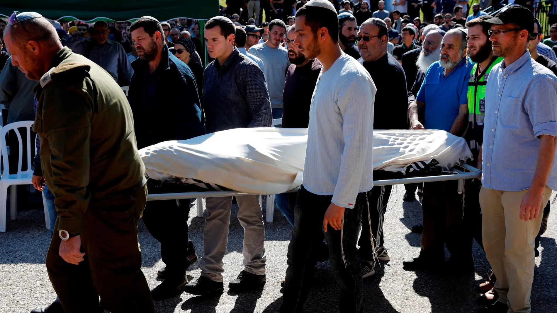 Varias personas acompañan el cadáver del rabino israelí Achad Ettinger, herido mortalmente en un ataque palestino.