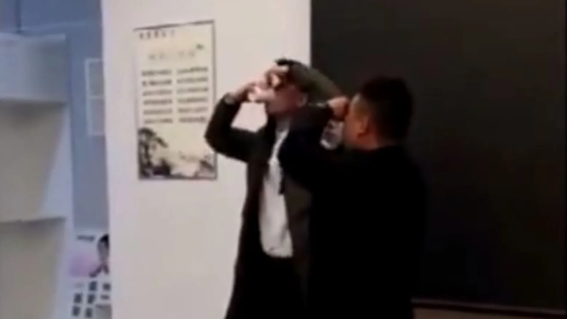 Dos empleados se tapan la nariz para beberse un vaso de orina