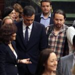 El presidente del Gobierno, Pedro Sánchez, acompañado de la vicepresidenta, Carmen Calvo y el líder de Podemos, Pablo Iglesias, a su llegada al Congreso