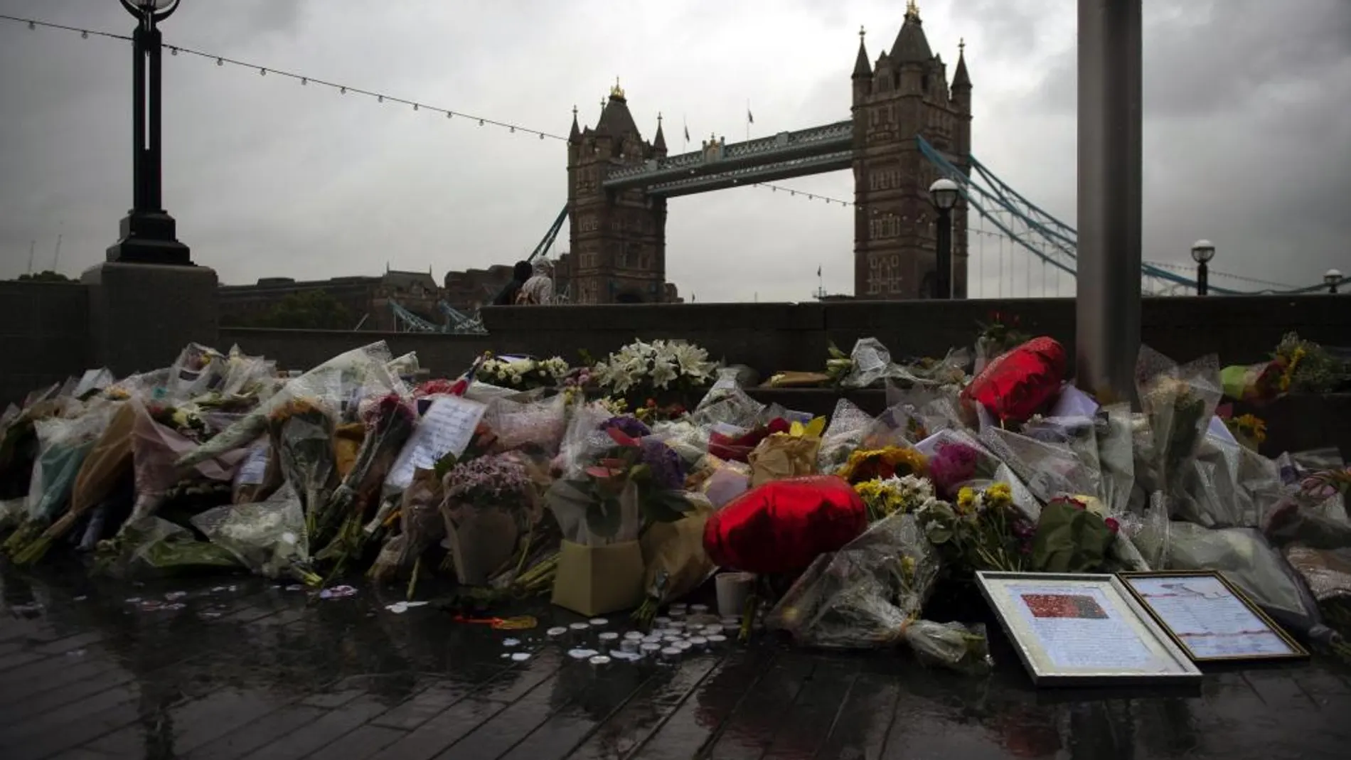 Varios ramos de flores, velas y mensajes dejados en memoria de las víctimas en los alrededores del Ayuntamiento, en Londres (Reino Unido)