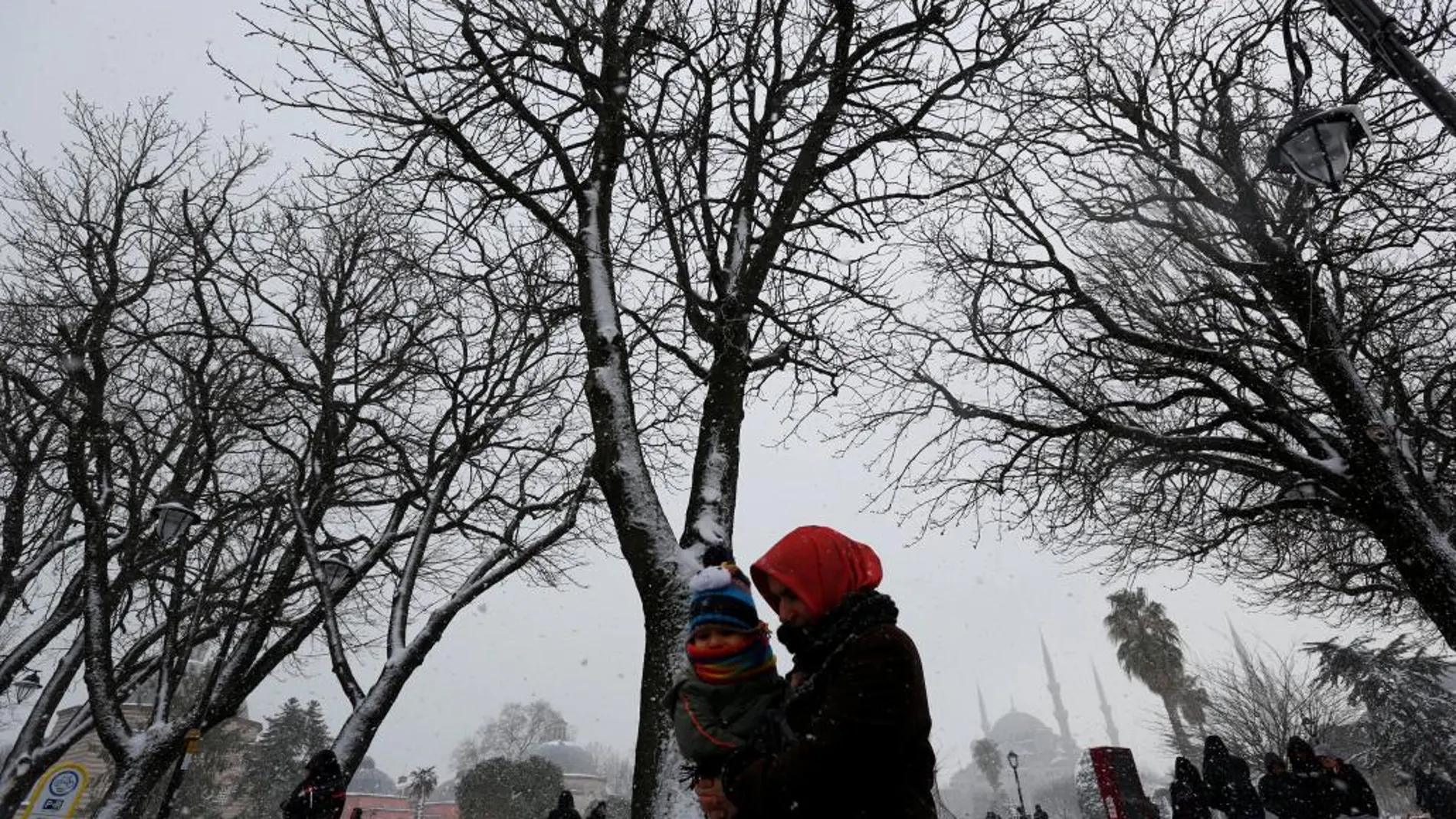 La gente pasea pese al frío y la nieve en la plaza Sultanahmet de Estambul, en Turquía.