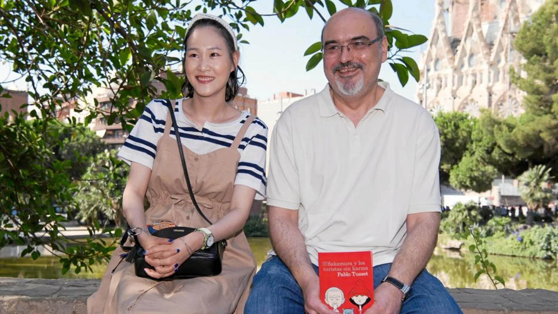 Pablo Tusset con una turista japonesa ayer frente la Sagrada Familia, escenario en el que arranca su nueva novela