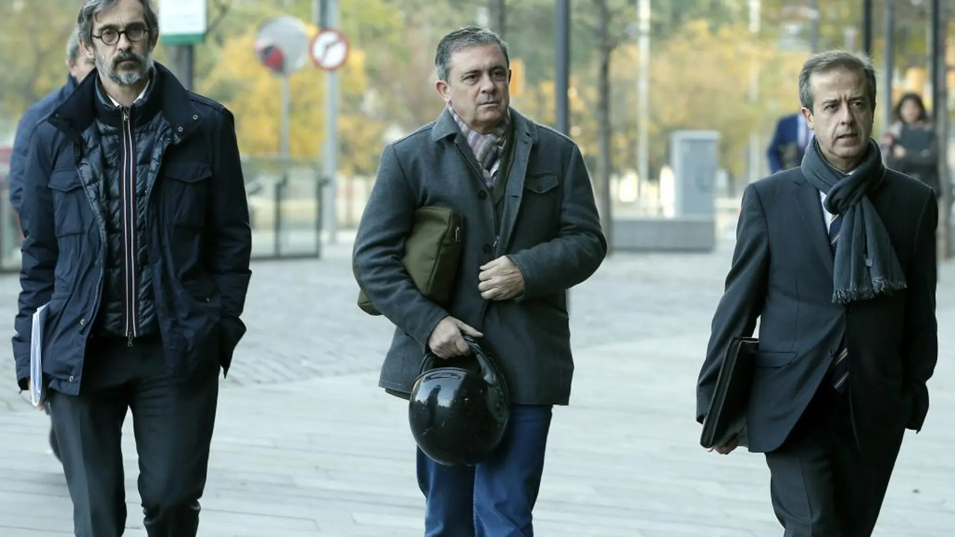 Jordi Pujol Ferrusola, primogénito del expresidente de la Generalitat (centro), acompañado de sus abogados Cristóbal Martell (izq.) y Javier Carrillo (dcha.), llega a los juzgados de guardia de Barcelona, donde ha acudido para entregar voluntariamente su pasaport