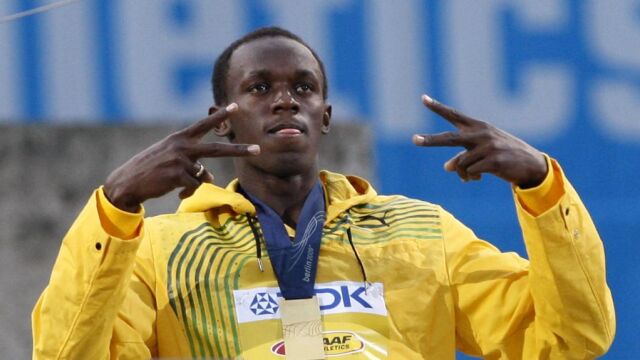 El atleta jamaicano Usain Bolt posa en el podio con la medalla de oro