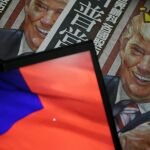 Una ilustración del presidente electo estadounidense Donald Trump en la portada de un periódico junto a la bandera taiwanesa en Taipei.