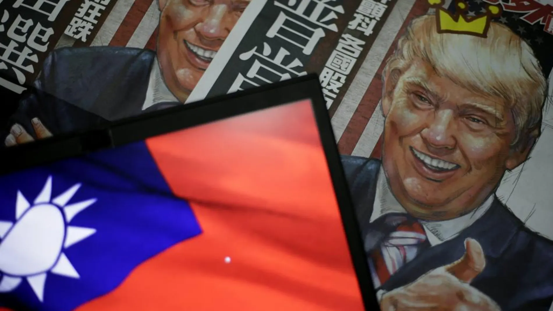 Una ilustración del presidente electo estadounidense Donald Trump en la portada de un periódico junto a la bandera taiwanesa en Taipei.