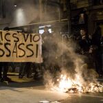 Varias personas sostienen una pancarta en la que se puede leer 'Policías, violadores, asesinos'
