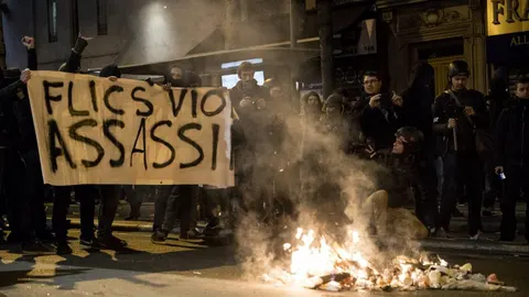 Varias personas sostienen una pancarta en la que se puede leer 'Policías, violadores, asesinos'