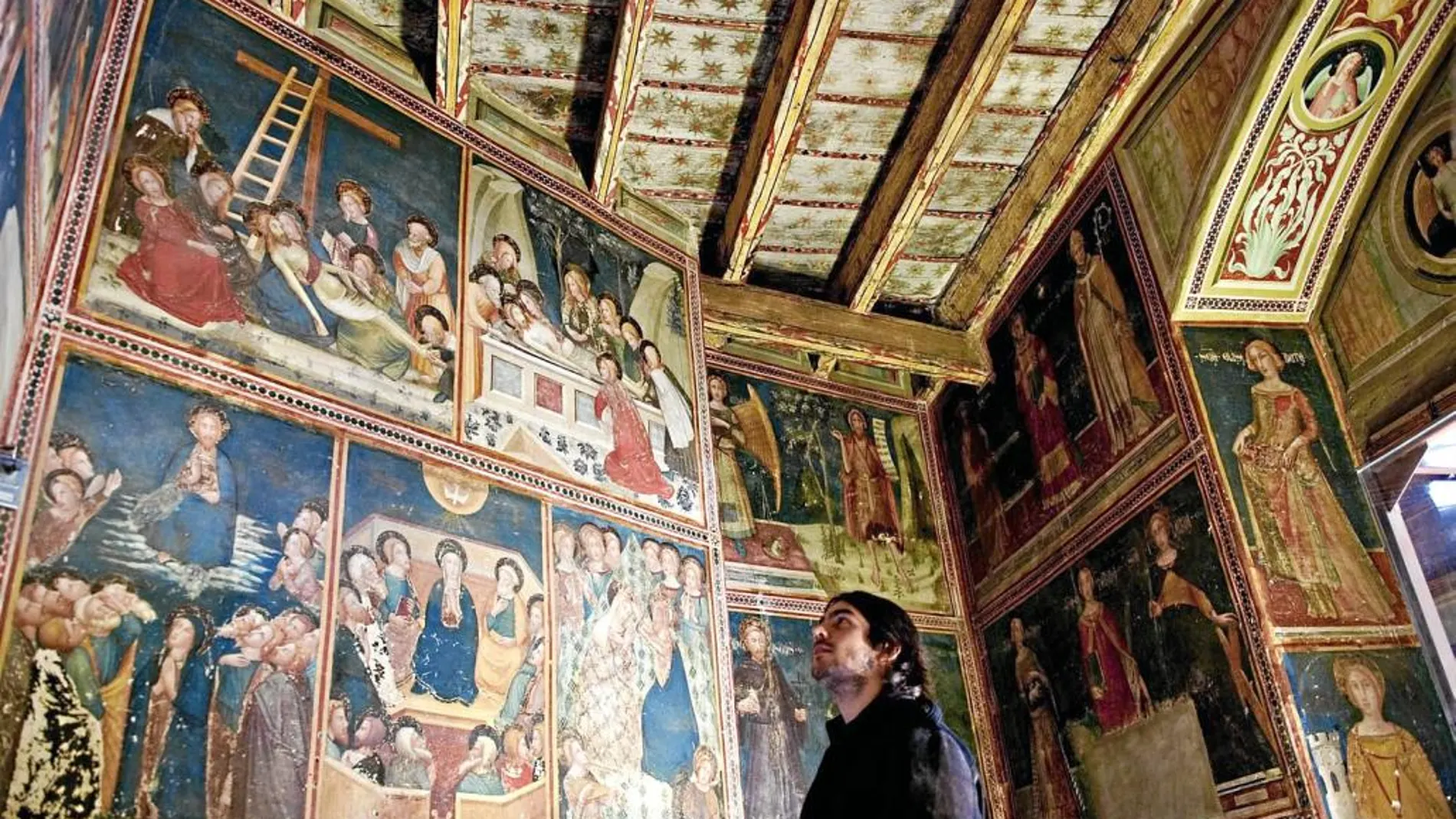 Un visitante contempla las pinturas medievales en la capilla de Sant Miquel del monasterio de Pedralbes